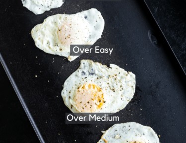 Fried eggs on a griddle cooked 4 different ways: sunny side up, over easy, over medium, and over hard