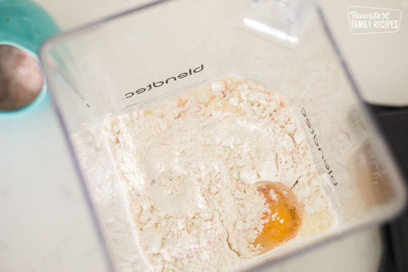 Ingredients for crepe batter including flour, eggs, vanilla, and salt in a blender