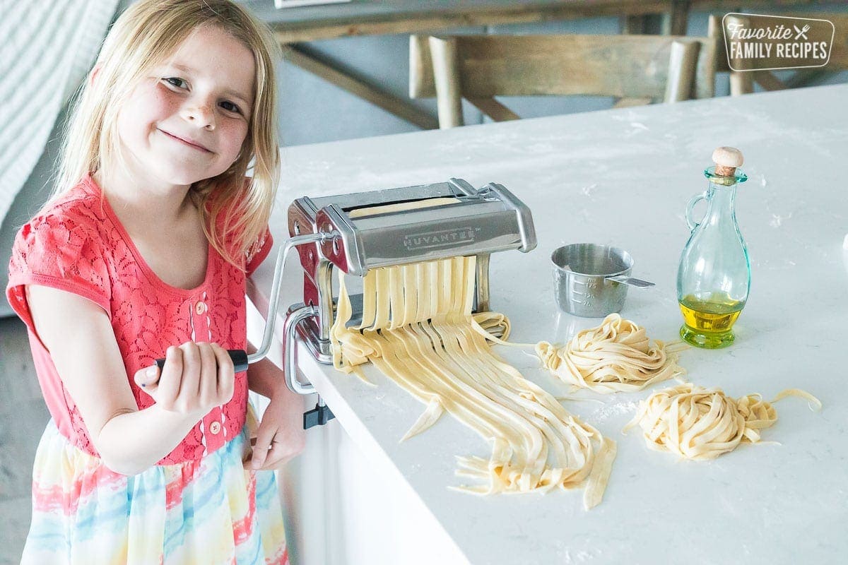 A little girl helping to make homemade pasta noodles