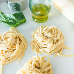 Three "nests" of homemade noodles on a cooking surface