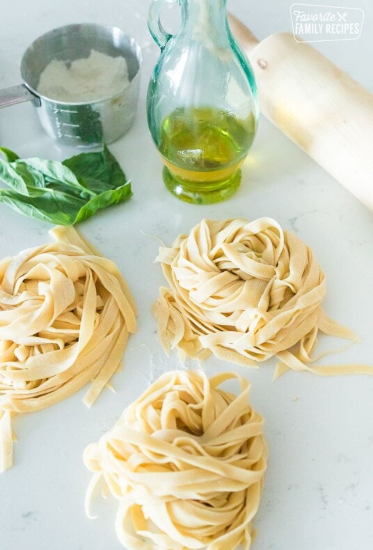 Three "nests" of homemade noodles on a cooking surface