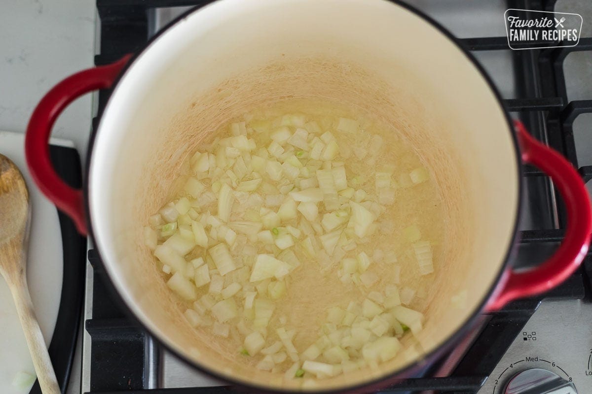 chopped onions sautéing in a Dutch oven on the stove
