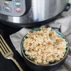 Brown rice in a small bowl next to an Instant Pot (Pressure Cooker)