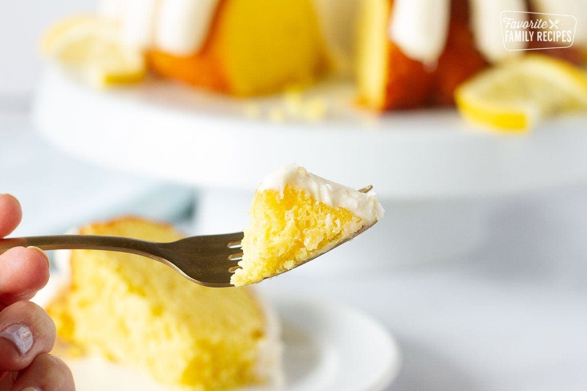 Close up of a fork with a piece of lemon nothing bundt cake.