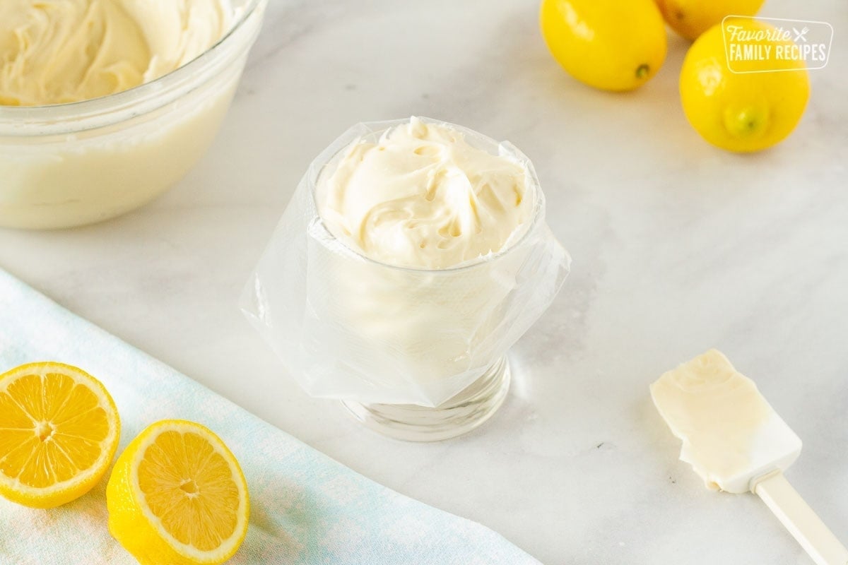 Frosting loaded in a piping bag using a cup for lemon nothing bundt cake.