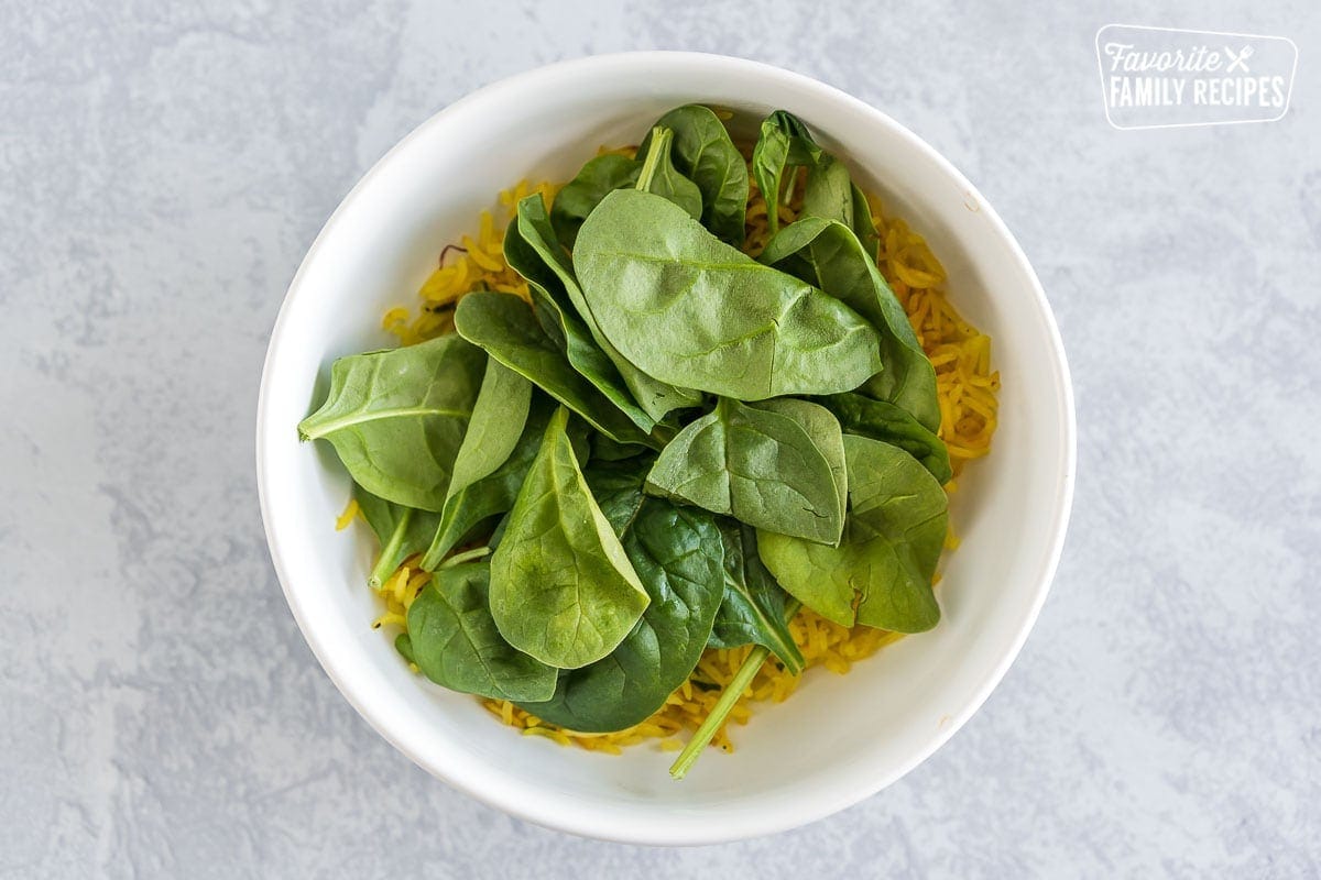 Saffron rice and spinach in a large white bowl