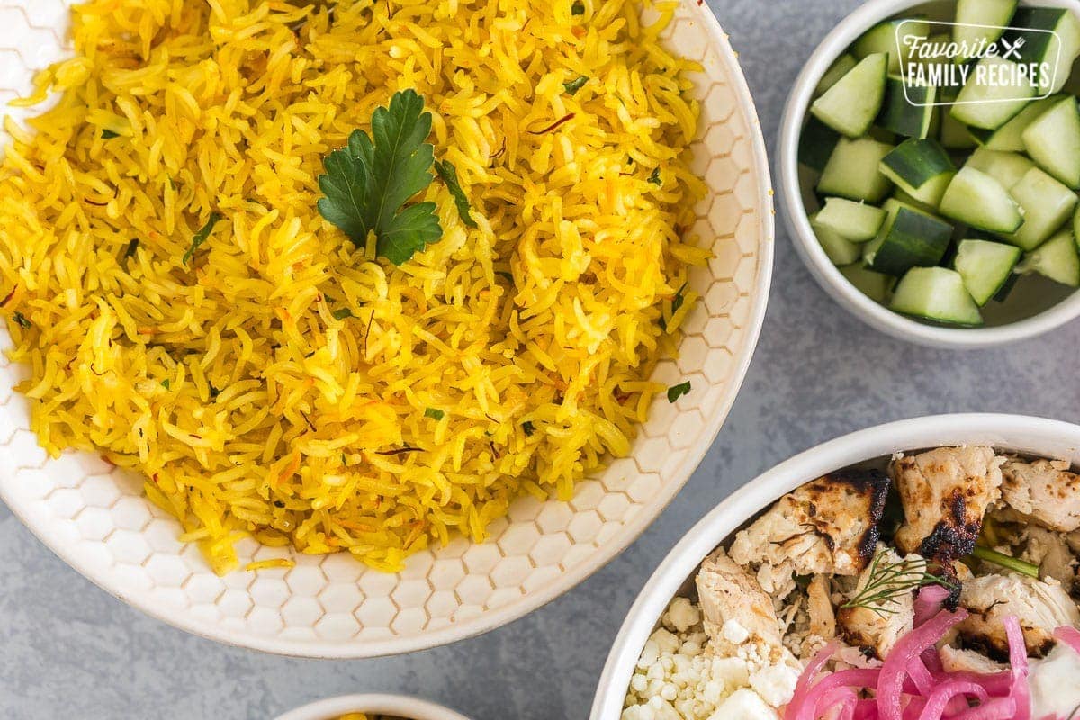 A bowl of saffron rice topped with a cilantro leaf