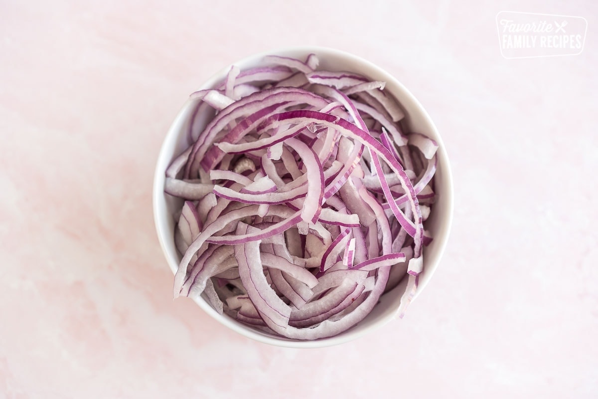 A bowl of thinly sliced red onions.