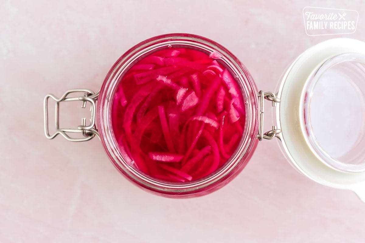 A glass jar full of pickled red onions