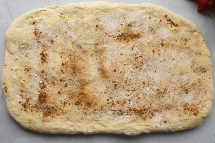 Rectangle dough with sprinkled sugar and cinnamon for Strawberry Cinnamon Twists.