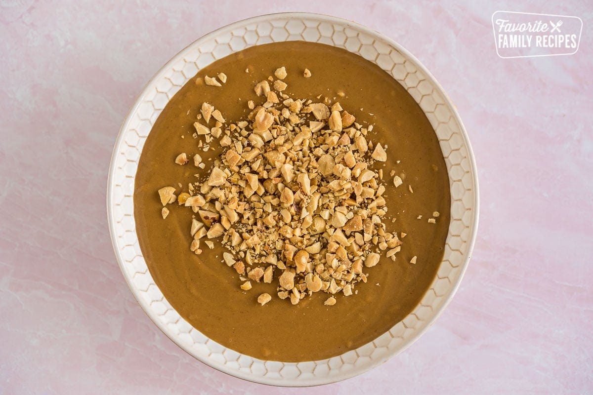 A bowl of peanut dipping sauce topped with chopped peanuts