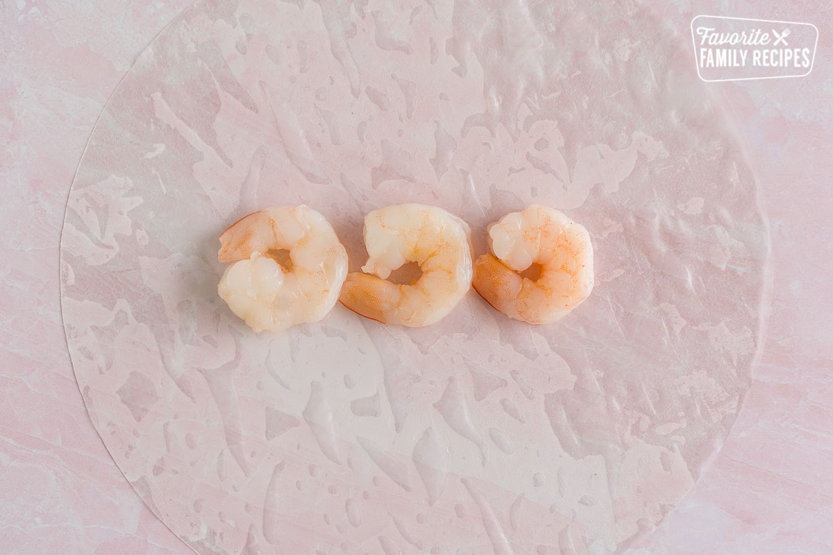 Three pieces of shrimp on a spring roll wrapper