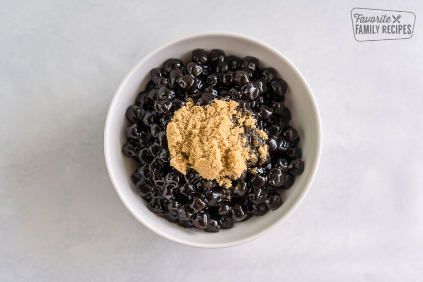 A bowl of boba pearls with a scoop of brown sugar on top