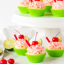 Multiple Cherry Limeade Cupcakes displayed on a cake stand.
