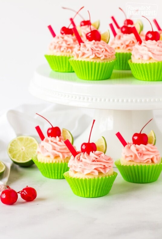 Multiple Cherry Limeade Cupcakes displayed on a cake stand.