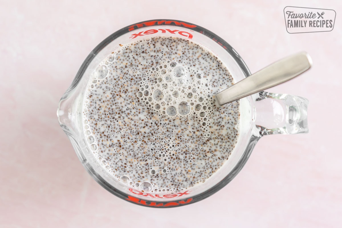 Chia seeds mixed into milk in a glass measuring cup