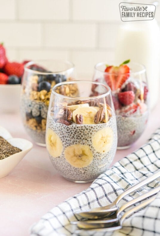 Three Chia Seed Pudding cups with fruit and nut toppings