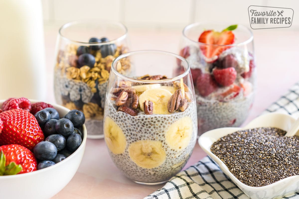 Three Chia Seed Pudding cups with fruit and nut toppings