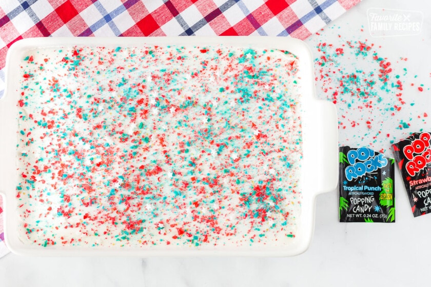 Pop Rocks sprinkled on top of frosted Firecracker Sugar Cookie Bars.