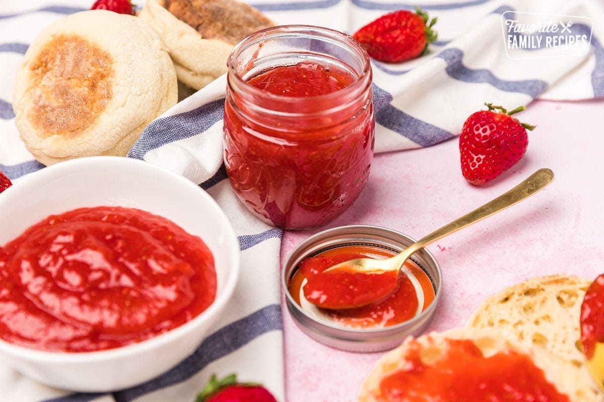 Processed strawberries in bowl and jar with english muffins