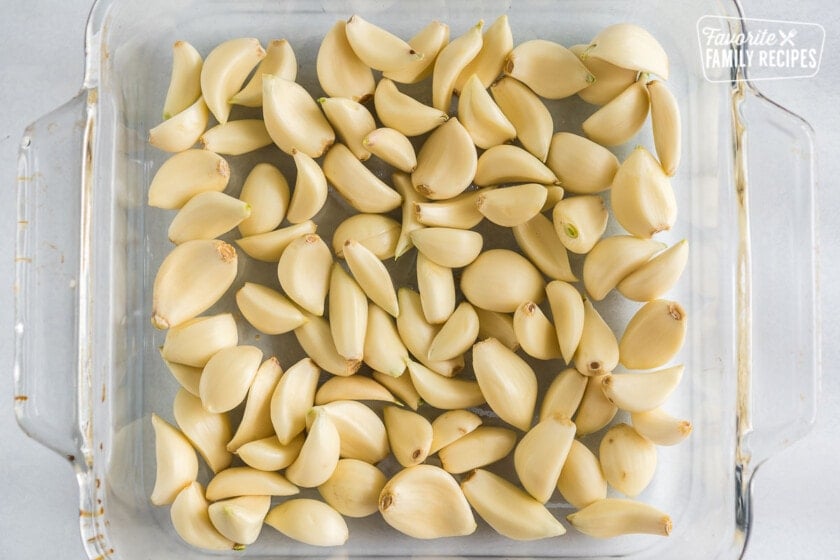 A baking dish full of whole, peeled garlic cloves
