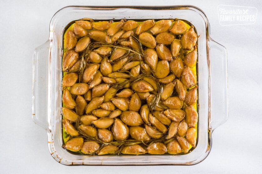 Garlic cloves baked in olive oil with rosemary sprigs