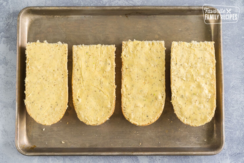 Four halves of french bread coated with garlic butter