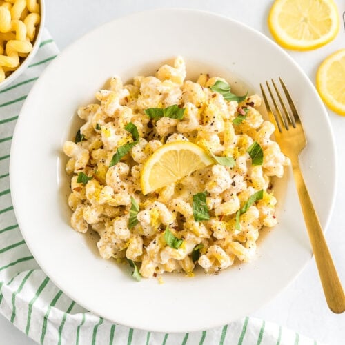 A bowl of Lemon Ricotta Pasta topped with basil leaves and a lemon slice