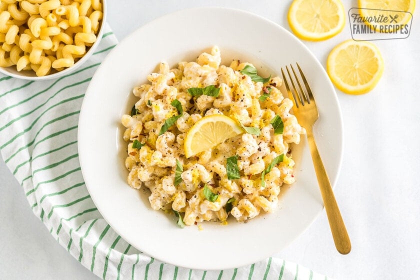 A bowl of Lemon Ricotta Pasta topped with basil leaves and a lemon slice