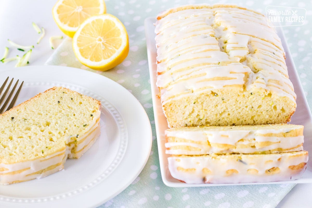 Sliced lemon zucchini bread with a slice on a separate plate.
