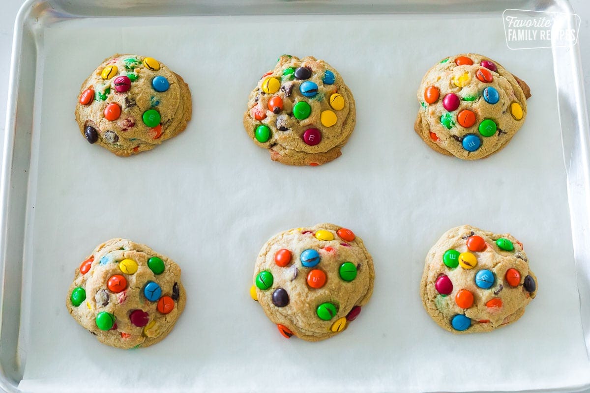 6 M&M cookies on a baking sheet