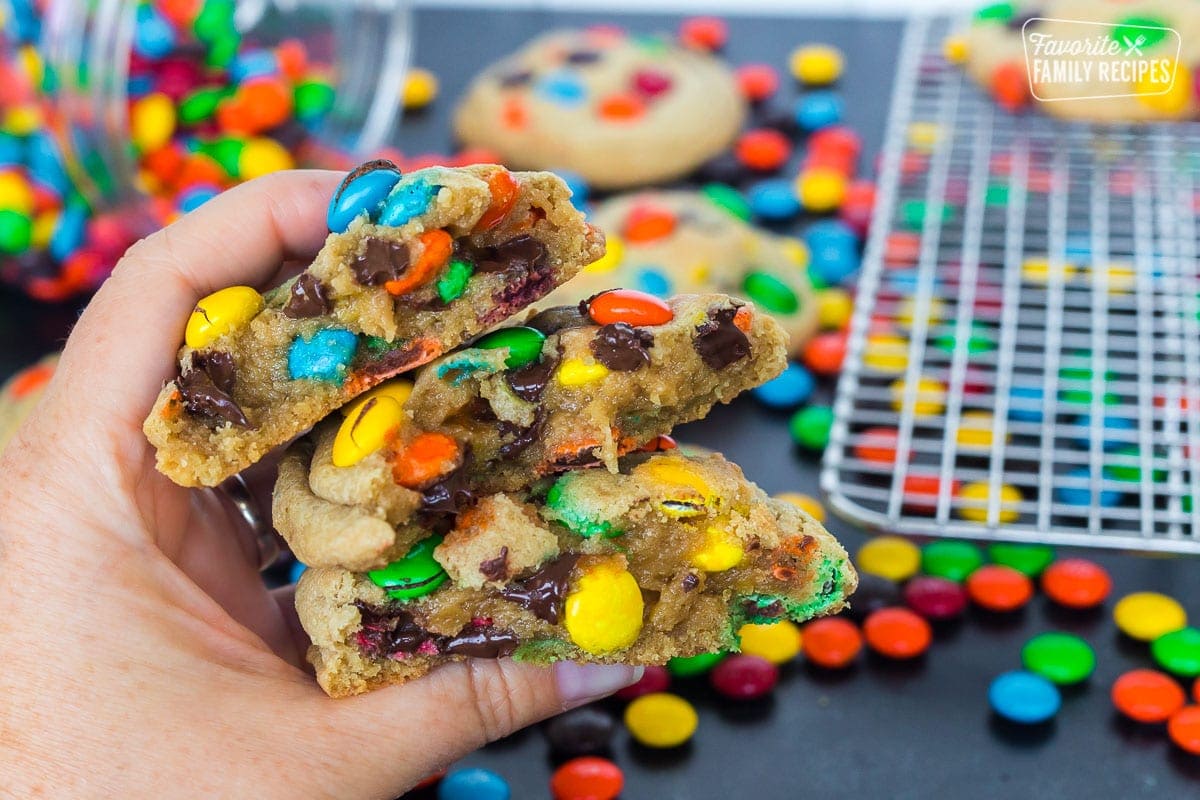 A close up of 3 M&M cookies that have been split in half to show the center of the cookie