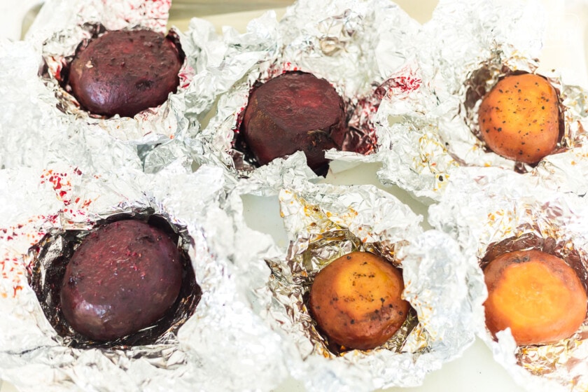 Roasted beets that were wrapped in foil and have been uncovered to show doneness.
