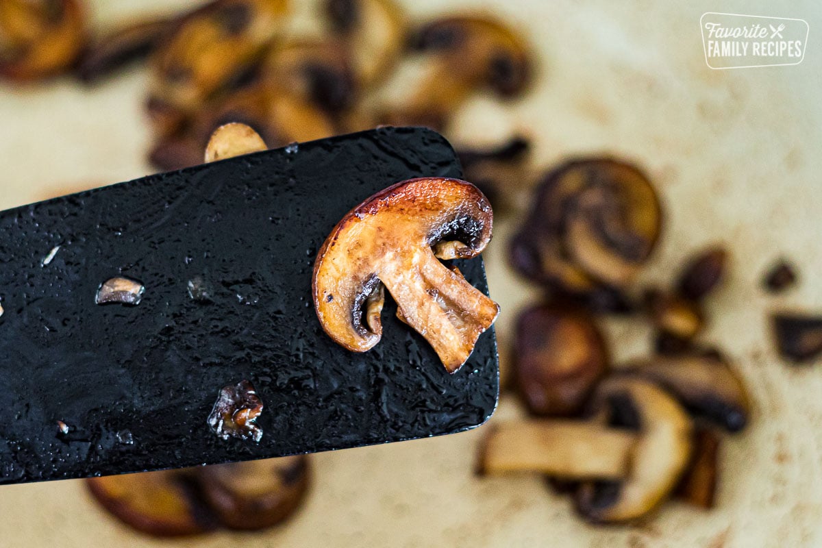 A close up of a sautéed mushroom on a spatula.