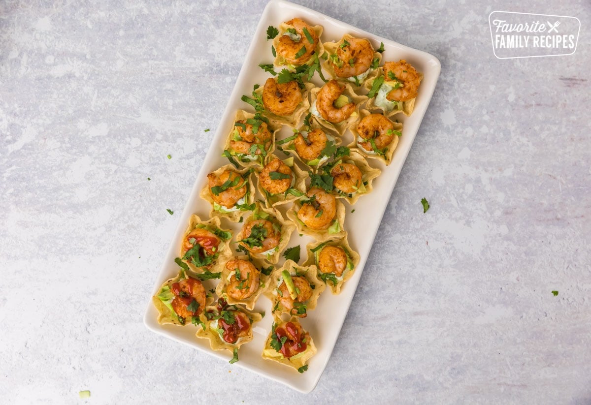 Scoop chips with cabbage, cilantro cream sauce, shrimp, cilantro on top