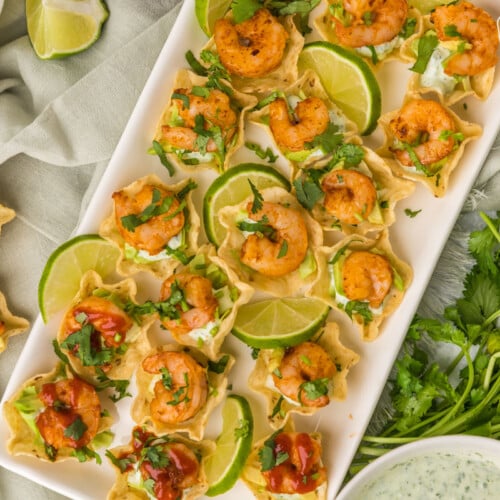 Plated shrimp taco bites with limes and cilantro
