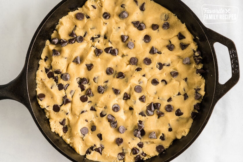 A cast iron skillet filled with cookie dough