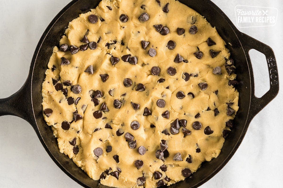 A cast iron skillet filled with cookie dough