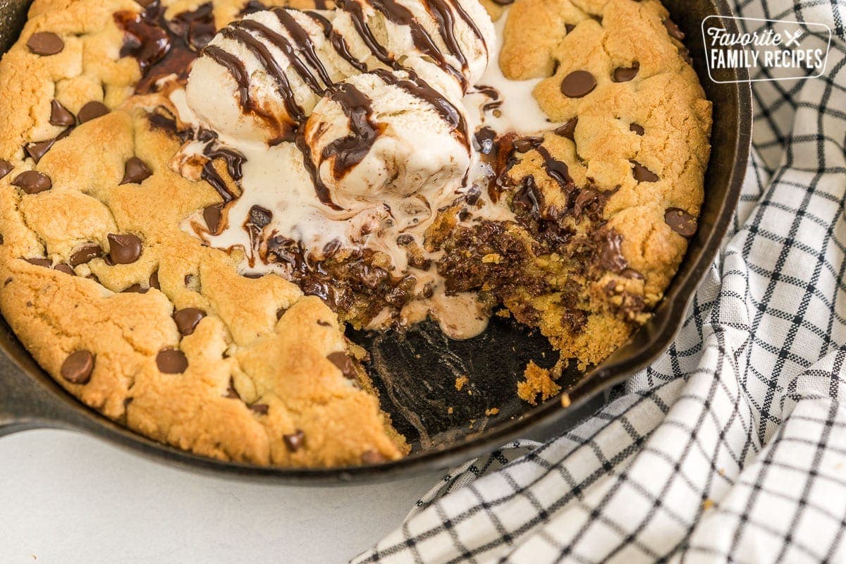 A skillet cookie with a piece taken out of it