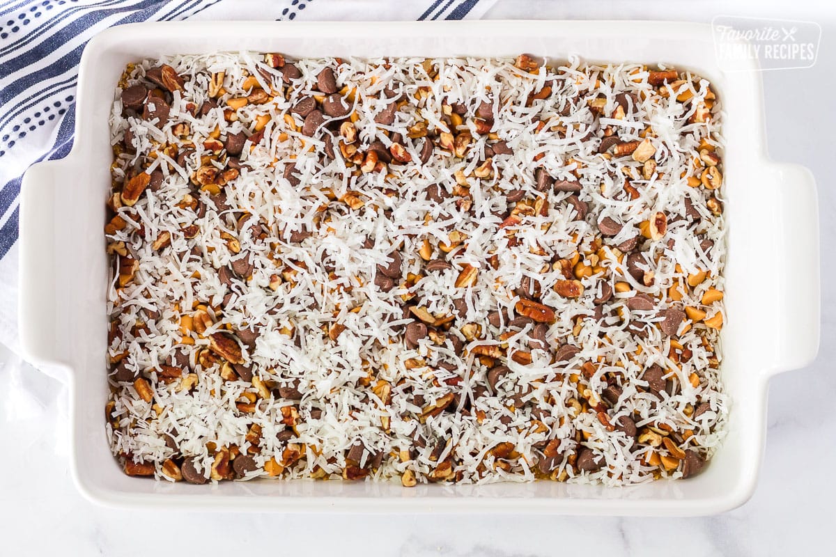 Top view of coconut, pecans, chocolate chips and pecan layers for 7 Layer Magic Cookie Bars.