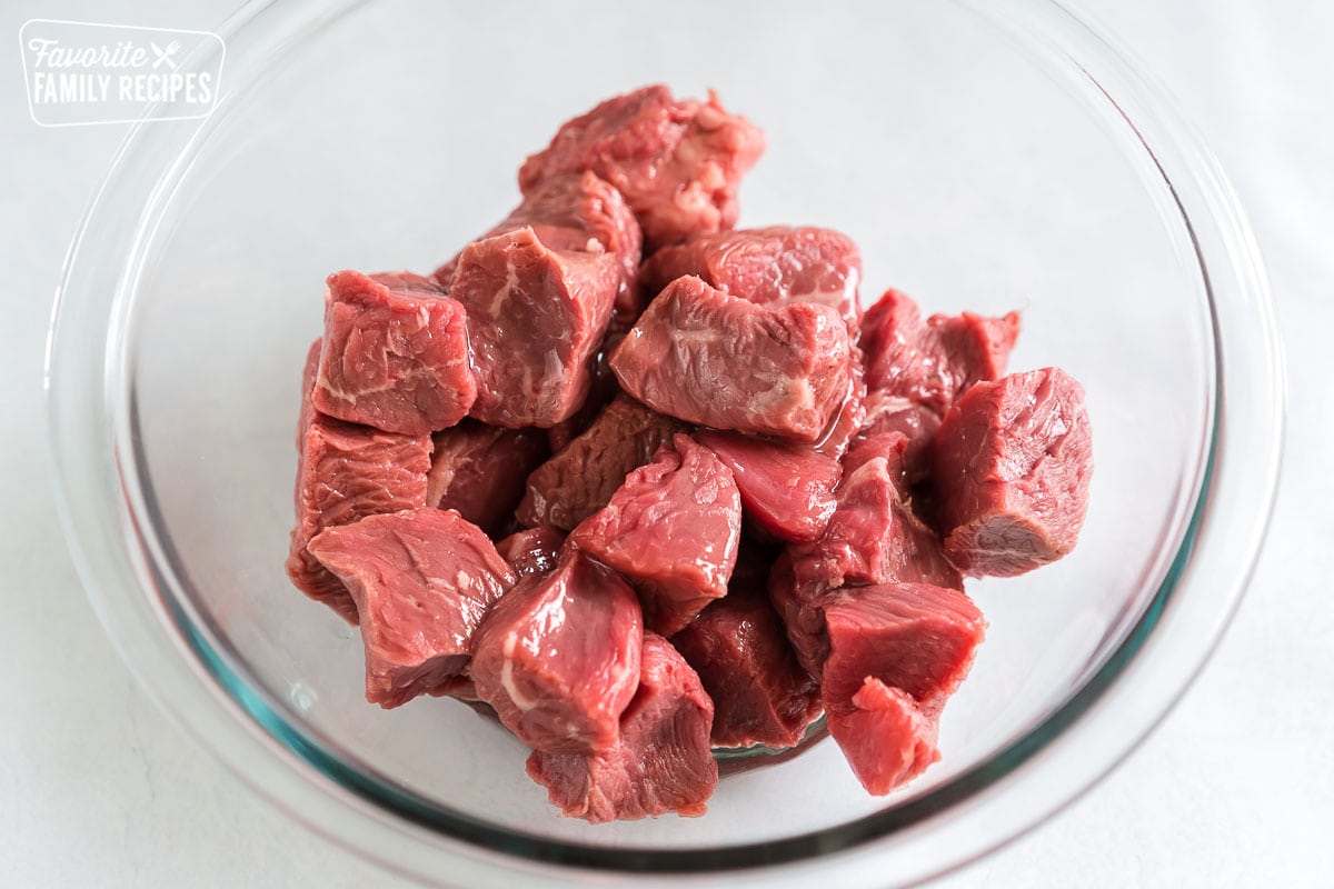 Cubed sirloin steak drizzled with oil in a bowl
