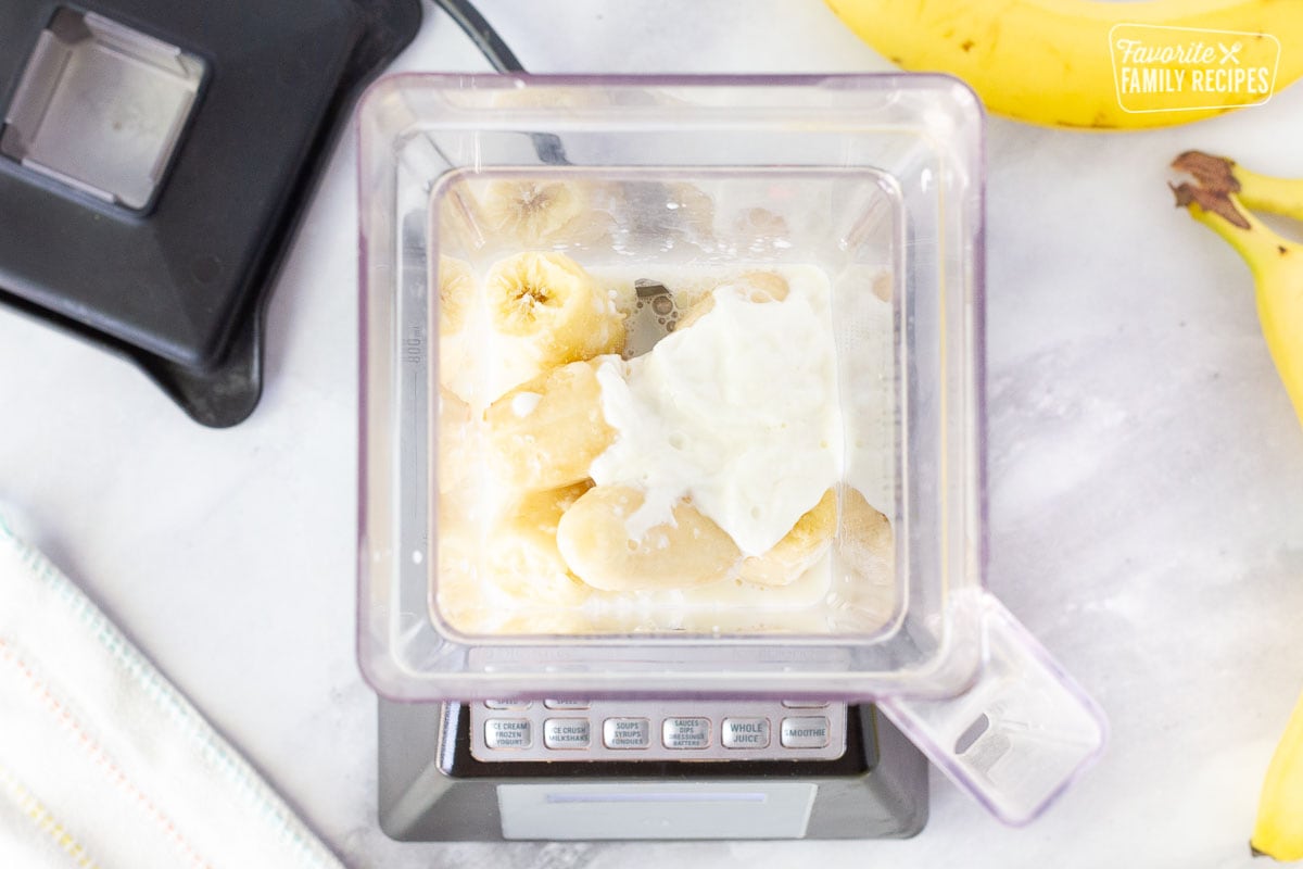 Frozen bananas, yogurt and milk in a blender for a banana smoothie.