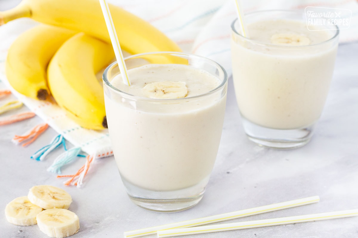 Two banana smoothies with straws.