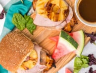 Big Kahuna Teriyaki Chicken Sandwiches on a wood board with watermelon