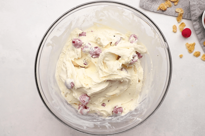 Bowl with cream and raspberries mixed together for Raspberry Fried Ice Cream.