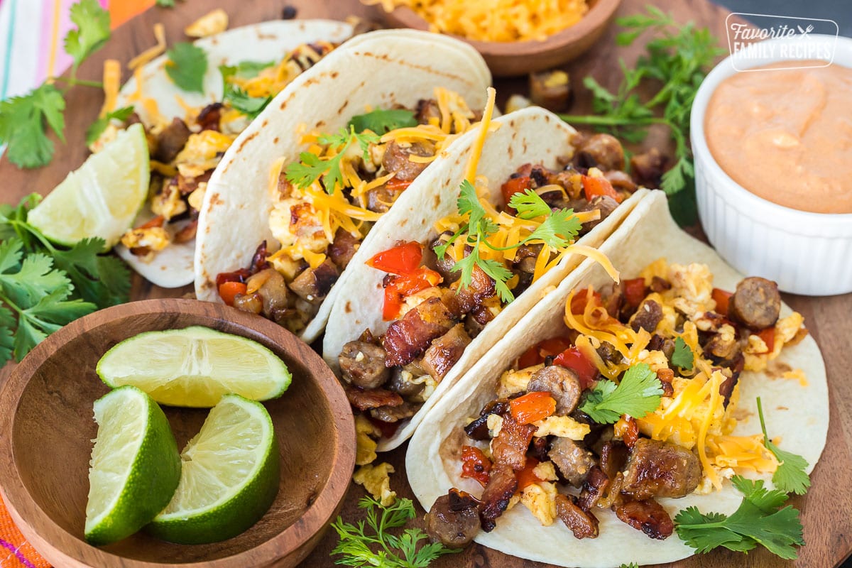 Four breakfast tacos made with sausage, bacon, and egg