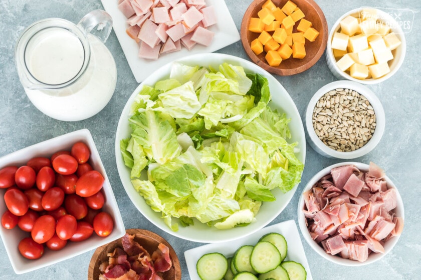 Lettuce, ham, cheese, cucumbers, ranch dressing and other ingredients to make a Chef Salad