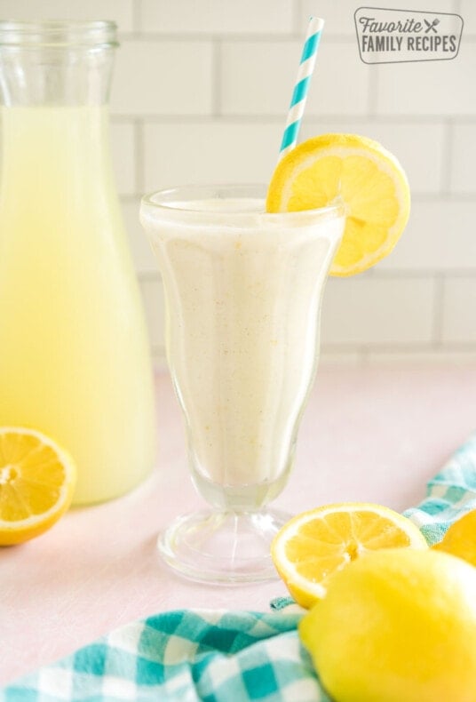 Chick Fil A Frozen Lemonade in a tall glass garnished with a lemon slice and a blue striped straw