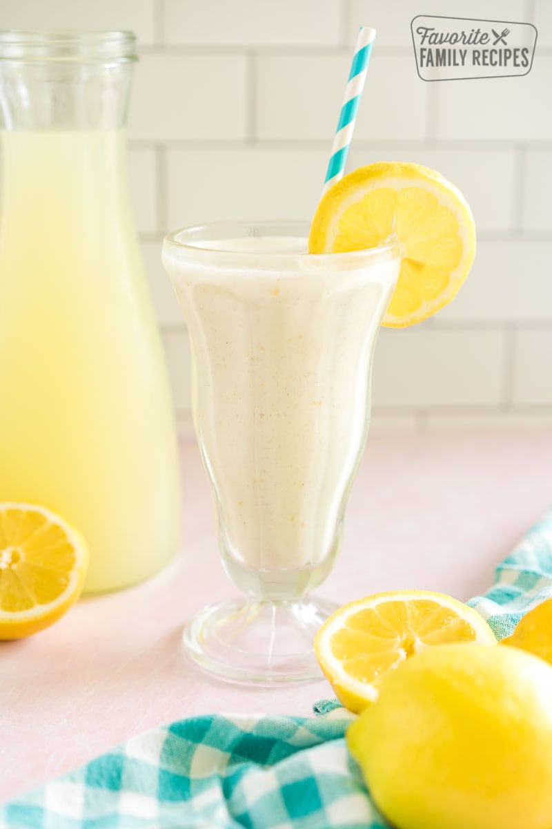 Chick Fil A Frozen Lemonade in a tall glass garnished with a lemon slice and a blue striped straw