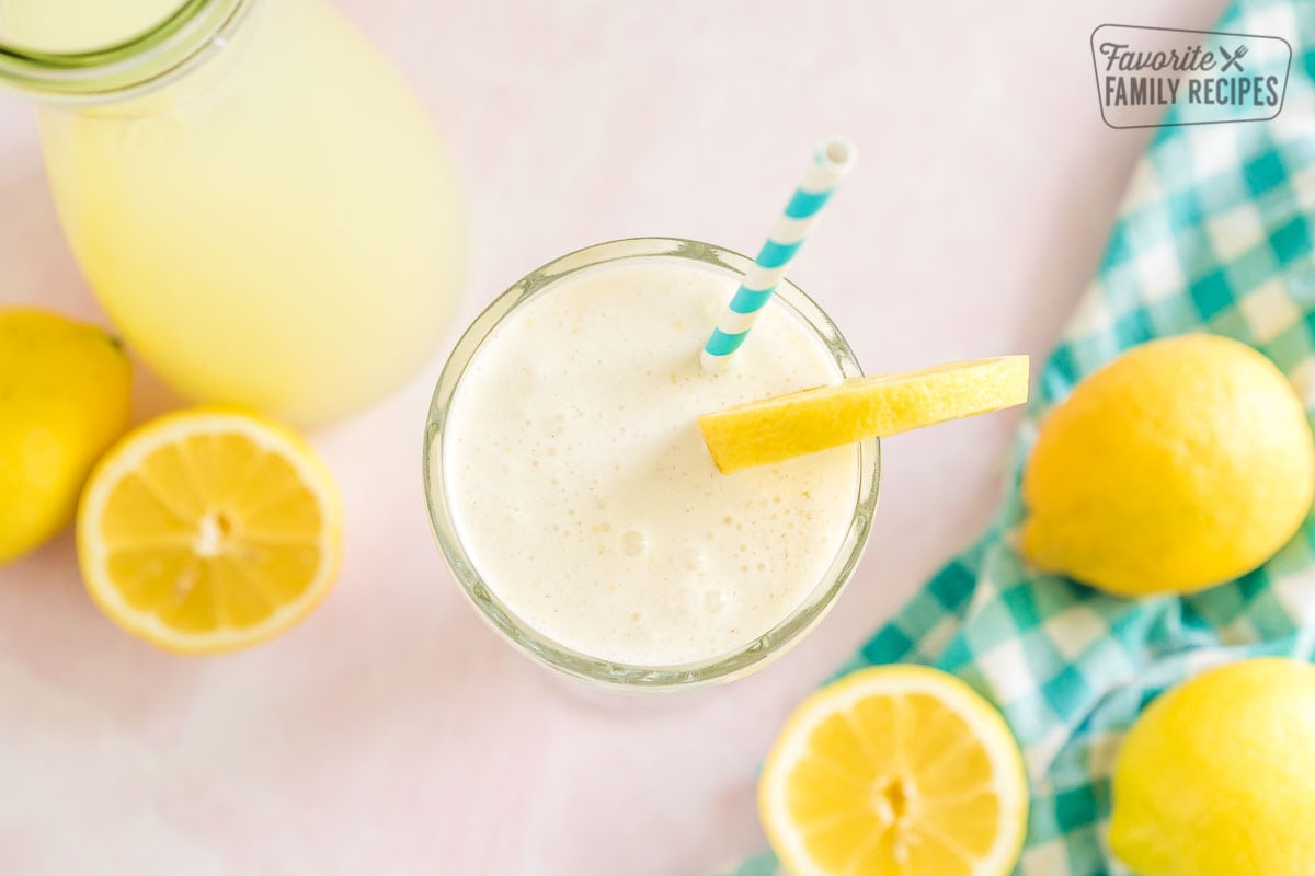 Chick Fil A frosted Lemonade in a tall glass garnished with a lemon slice and a blue striped straw.